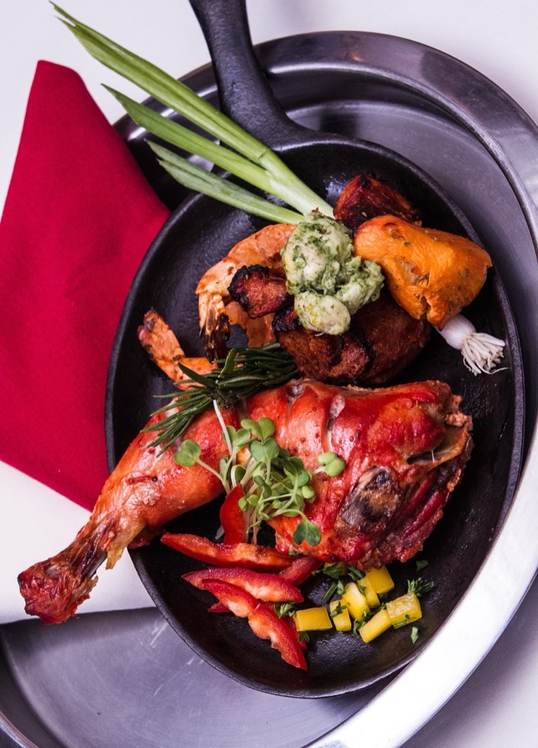 Tandoori platter on a black plate, straight off the charcoal